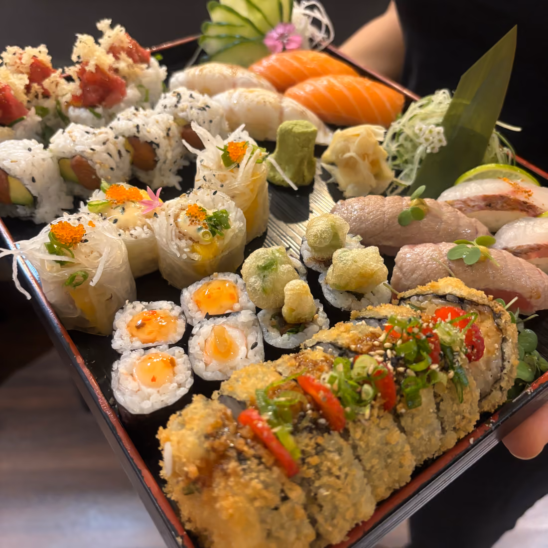 Una fuente para compartir Sushi Moriawase con nigiri, maki y rolls con topping crujiente en Hito