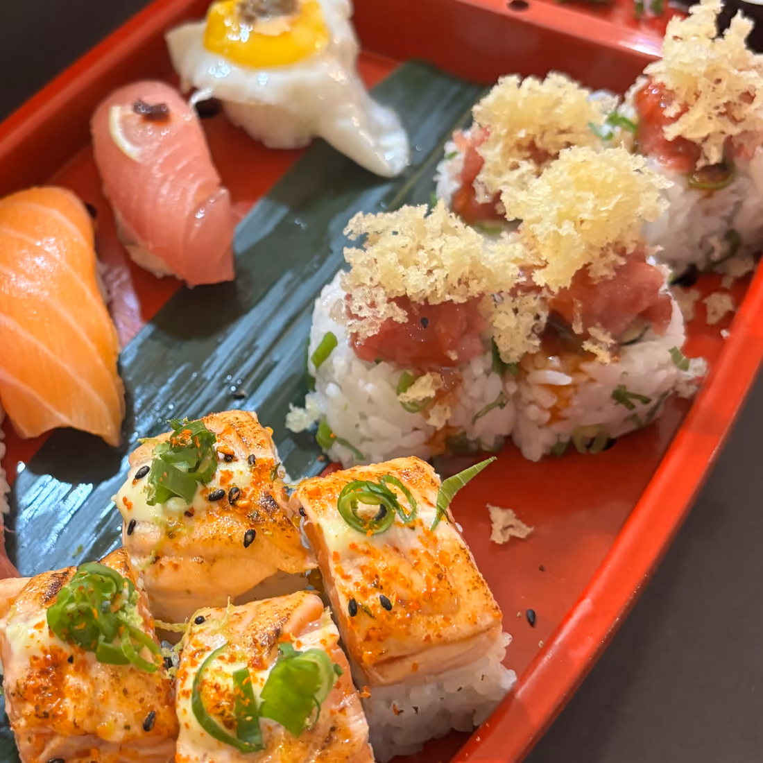 Uramaki Netto Roll con atún flambeado y aguacate sobre un barco de laca roja en Hito