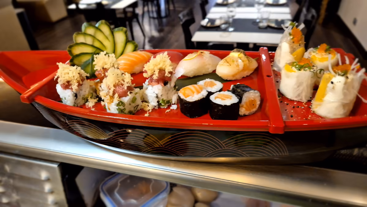 Un barco de sushi de laca en Hito con nigiri, hosomaki de salmón y rolls con topping crujiente
