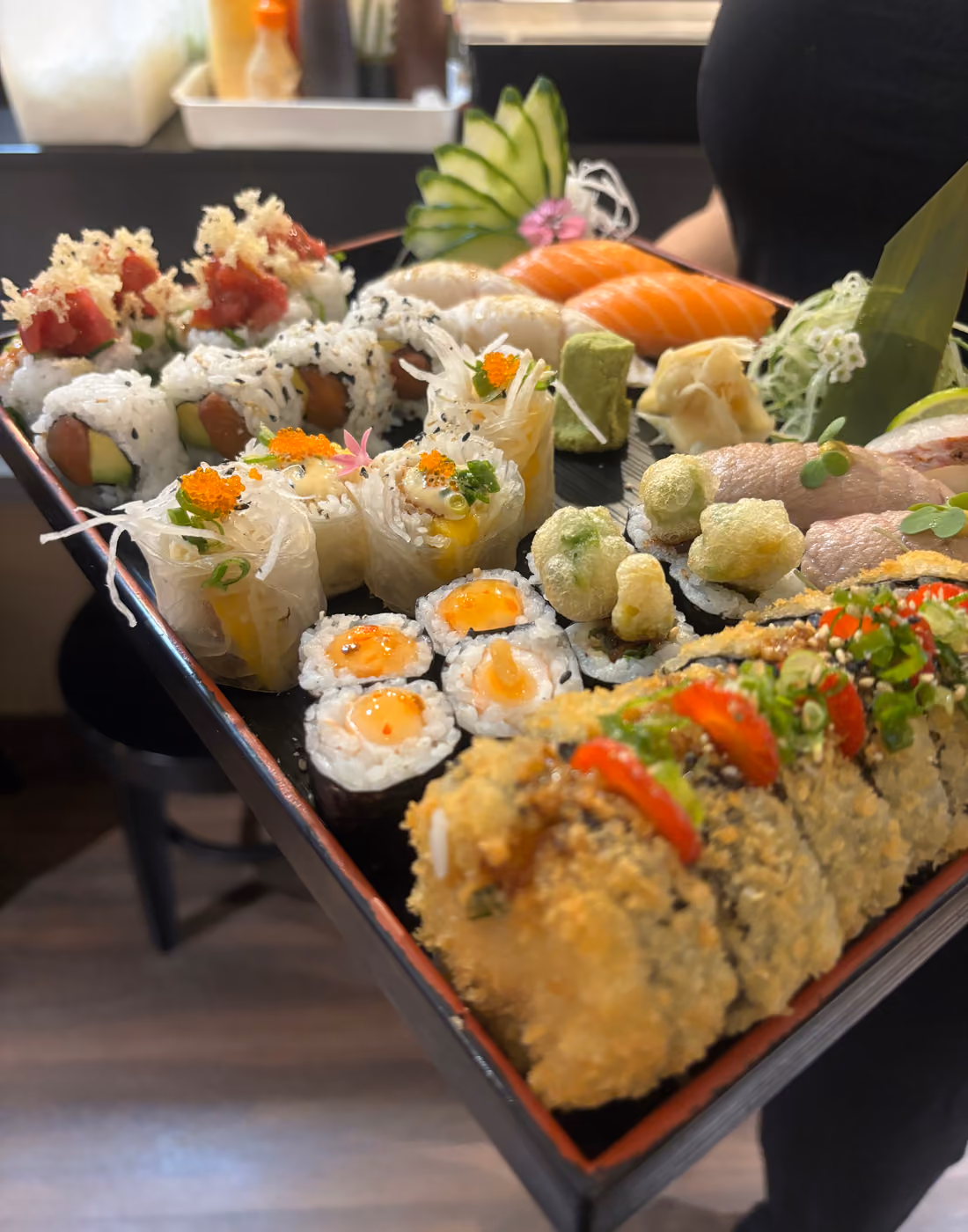 Una gran bandeja para compartir con maki, uramaki y nigiri llevada a una mesa en Hito