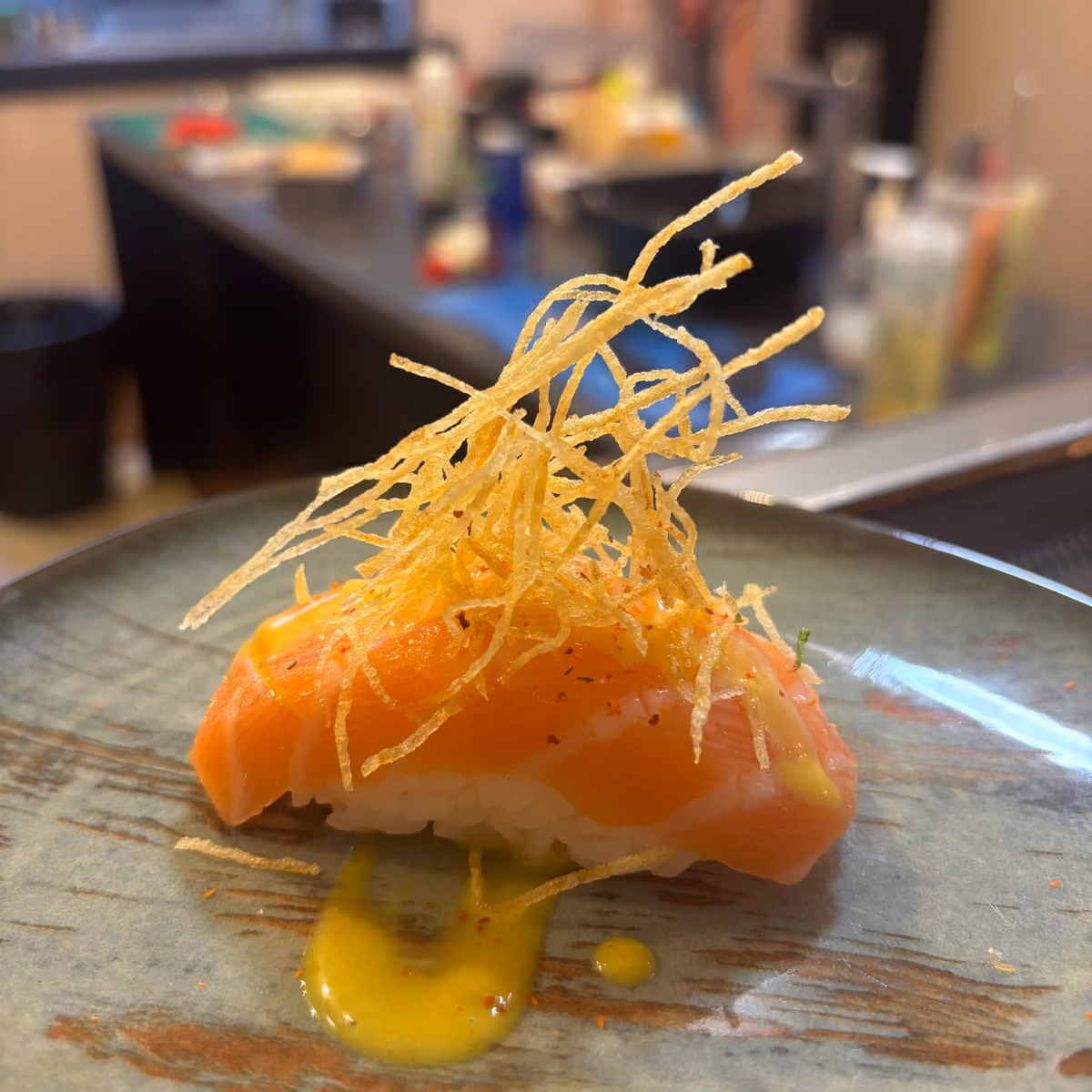Nigiri Sake Especial - nigiri de salmón flambeado con topping crujiente - en un plato de gres en Hito