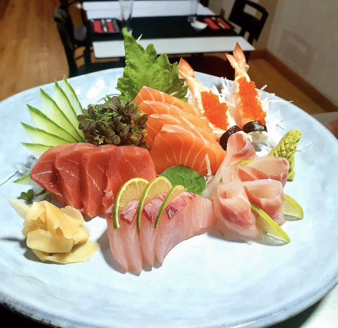 Un Sashimi Moriawase de atún, salmón, pescado blanco y langostino con guarniciones frescas en Hito